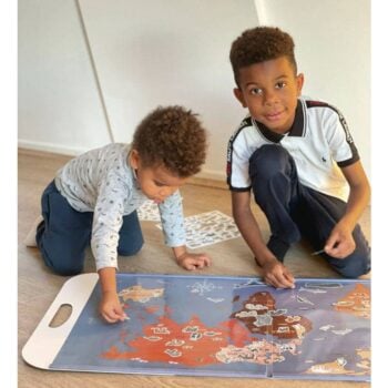 Dwoje dzieci układają dużą magnetyczną mapę świata ze zwierzętami na podłodze. Egmont Toys Duża układanka magnetyczna Zwierzęta Świata