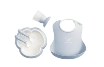 Zestaw do karmienia dla dziecka w kolorze jasnoniebieskim z miską, sztućcami i śliniakiem z kieszonką. BABYBJORN Zestaw obiadowy Powder Blue