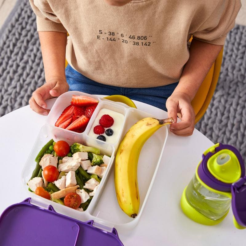 Fioletowa śniadaniówka z przegródkami z jedzeniem dla dziecka banan truskawki maliny borówki sałatka z kurczakiem i pomidorami zielona butelka na napój. b.box Lunchbox Lilac Pop