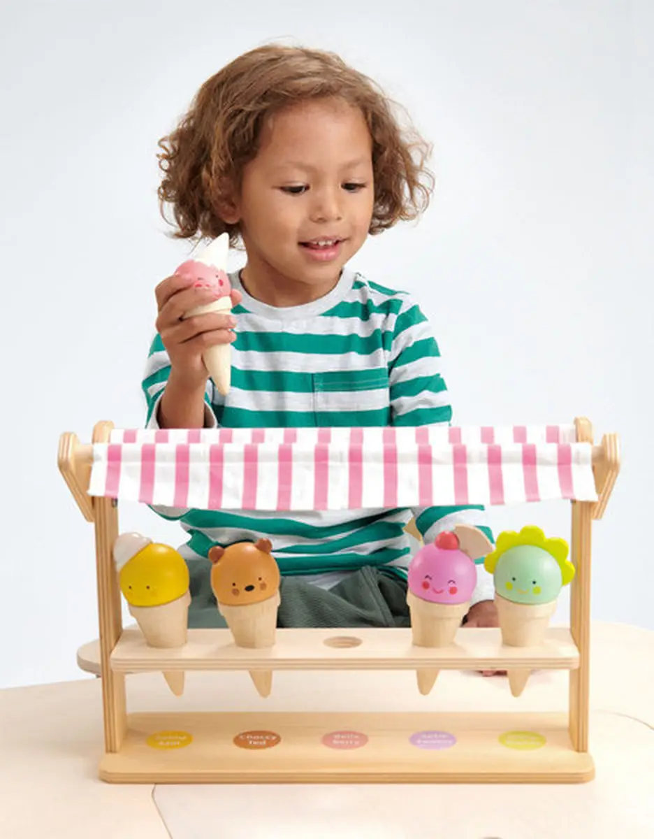 Dziecko bawiące się mini lodziarnią z drewnianymi lodami w rożkach w pastelowych kolorach. Tender Leaf Toys Mini lodziarnia z lodami w rożkach
