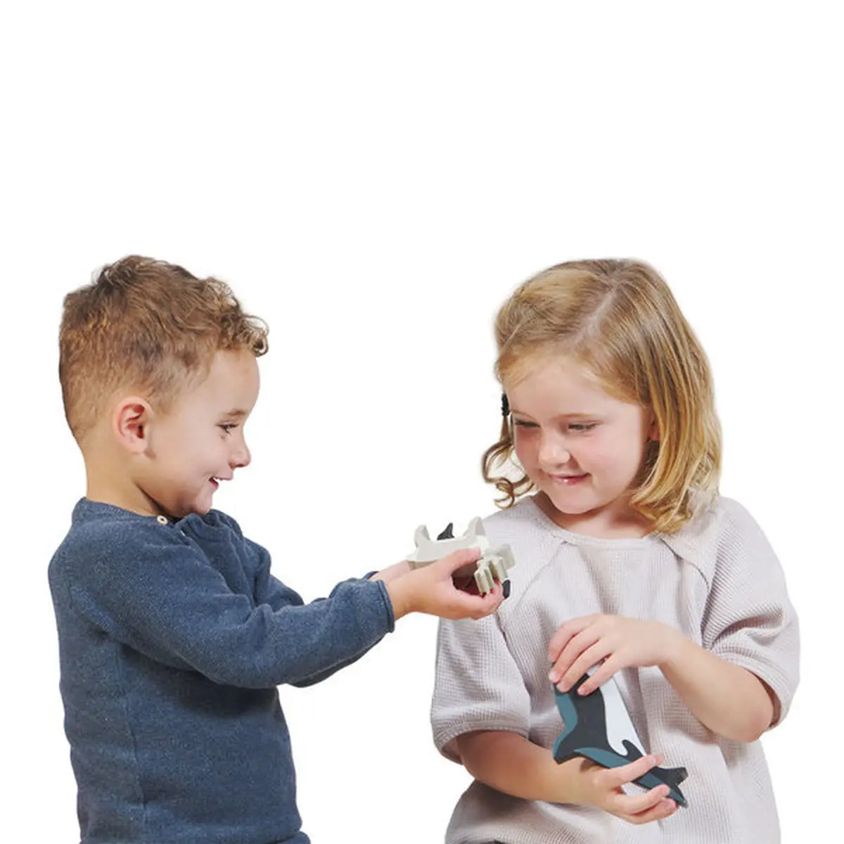 Dwoje dzieci bawiących się drewnianymi figurkami zwierząt polarnych dla dzieci. Tender Leaf Toys Drewniane figurki do zabawy zwierzęta polarne