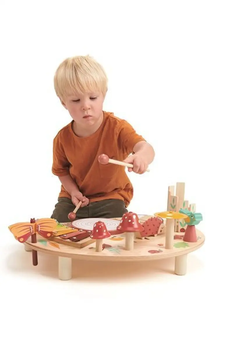 Dziecko grające na drewnianym stoliku muzycznym z kolorowymi instrumentami dla dzieci. Tender Leaf Toys Drewniany stolik muzyczny