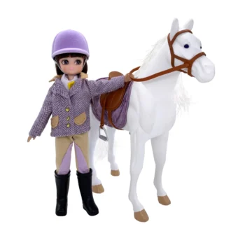 Lalka dżokejka ubrana w fioletowy kask i marynarkę stojąca obok białego konika z siodłem dla dziecka. Bigjigs Toys Lottie Lalka dżokejka z konikiem