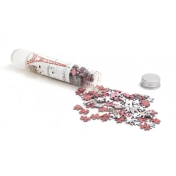 Puzzle kieszonkowe mikro menzurka z motywem Wieży Eiffla elementy rozsypane obok przezroczystej tuby. Londji Puzzle mikro menzurka Wieża Eiffla