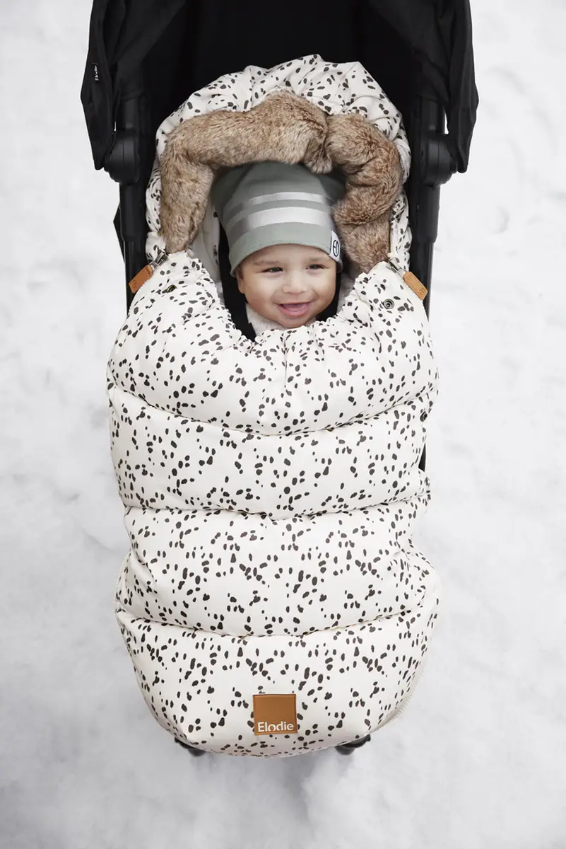 Dziecko w zielonej czapce zimowej dla niemowlaka w wózku na śniegu. Elodie Details Czapka Hazy Jade 0-6 m-cy