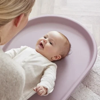 Fioletowa mata do przewijania z pianki z zaokrąglonymi krawędziami niemowlę leżące na macie dla dziecka. Shnuggle Mata do Przewijania z Pianki Squishy Blossom