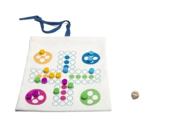 Podróżna gra planszowa 2w1 chińczyk i drabinka z kolorowymi pionkami i kostką na białym materiale. BS Toys Podróżna gra 2w1 chińczyk drabinka