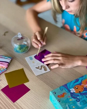 Zabawki z syrenką – dziecko tworzące podwodne terrarium