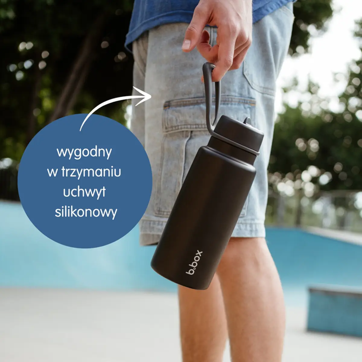 Czarny termos ze stali nierdzewnej z silikonowym uchwytem trzymany w dłoni mężczyzny. b.box Butelka termiczna ze składanym ustnikiem – termos ze stali nierdzewnej 1l White Out