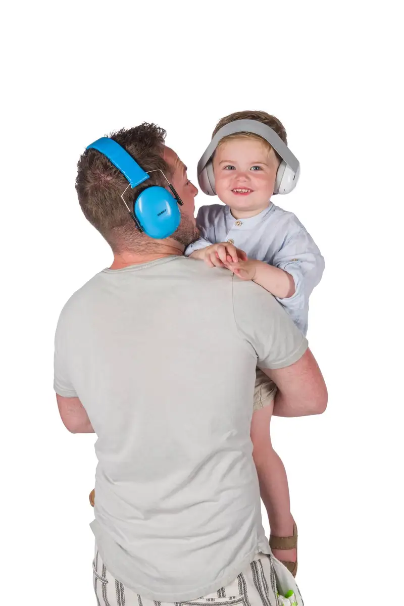 Mężczyzna z niebieskimi słuchawkami ochronnymi dziecko z białymi słuchawkami ochronnymi dla niemowląt 0-3 lat. Dooky Słuchawki ochronne Baby Earmuff white 0-3 l