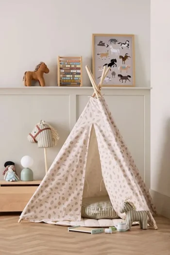 Dziecięcy namiot tipi w beżowe kropki z poduszką i zabawkami w pokoju dziecięcym. Kid’s Concept Namiot Tipi dot