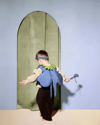Dziecko w niebieskim kostiumie jagodowej wróżki z zielonym kołnierzem i opaską na głowie trzymające różdżkę. Kid’s Concept Kostium jagodowej wróżki