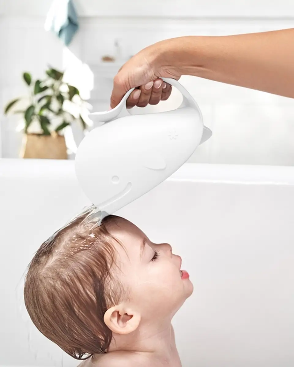 Biały kubek do mycia głowy w kształcie wieloryba używany do polewania wody dziecku podczas kąpieli. Skip Hop Kubek do Mycia Głowy Wieloryb Moby White 710 ml