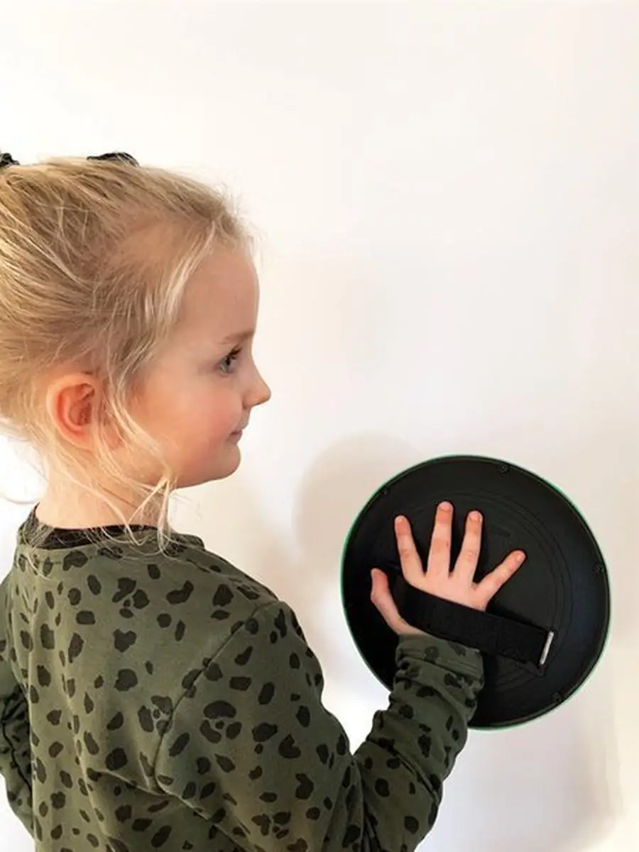 Dziewczynka trzymająca czarną paletkę do gry zręcznościowej dla dzieci. Scratch Gra zręcznościowa Paletki rzucaj i łap Robot