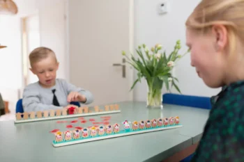 Drewniana gra logiczna z postaciami krów dla dzieci na stole w pokoju. BS Toys drewniana gra logiczna Zgadnij która krówka?