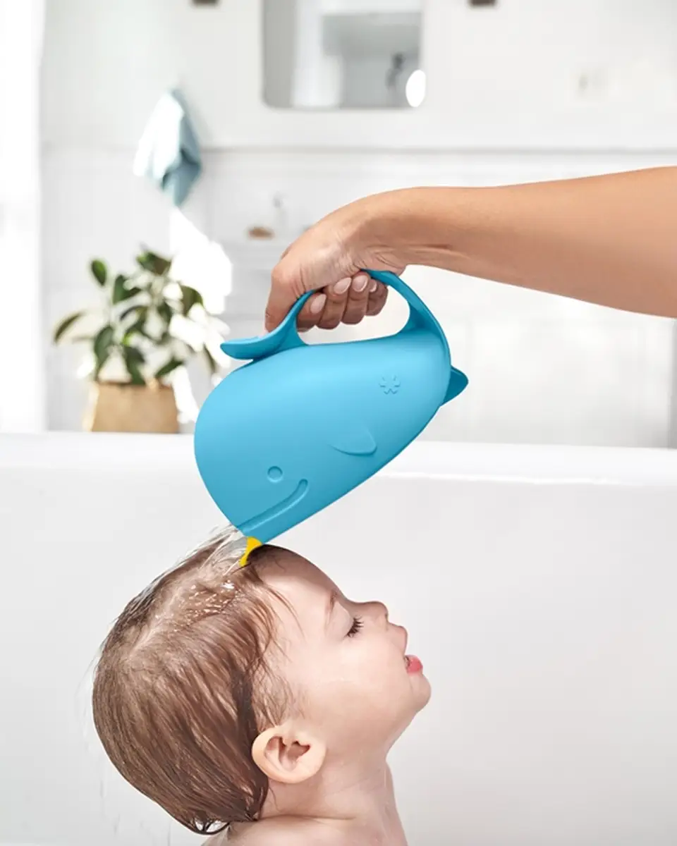 Niebieski kubek do mycia głowy w kształcie wieloryba używany do polewania głowy dziecka podczas kąpieli. Skip Hop Kubek do Mycia Głowy Wieloryb Moby Blue 710 ml