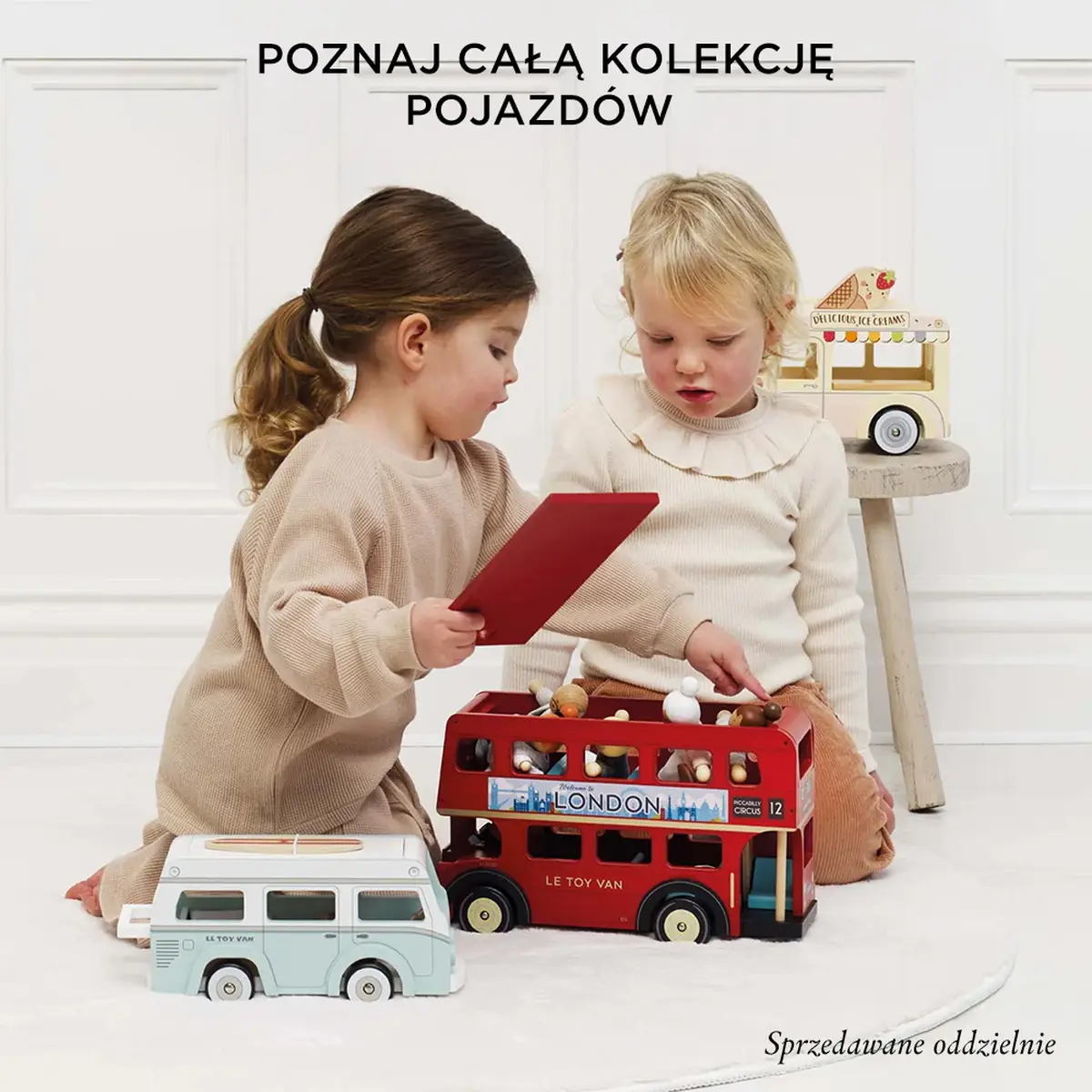 Dwie dziewczynki bawiące się drewnianymi zabawkami pojazdami czerwonym autobusem i białym vanem dla dzieci. Le Toy Van Drewniany samochód retro kawiarnia zabawka dla dzieci sklep kawa
