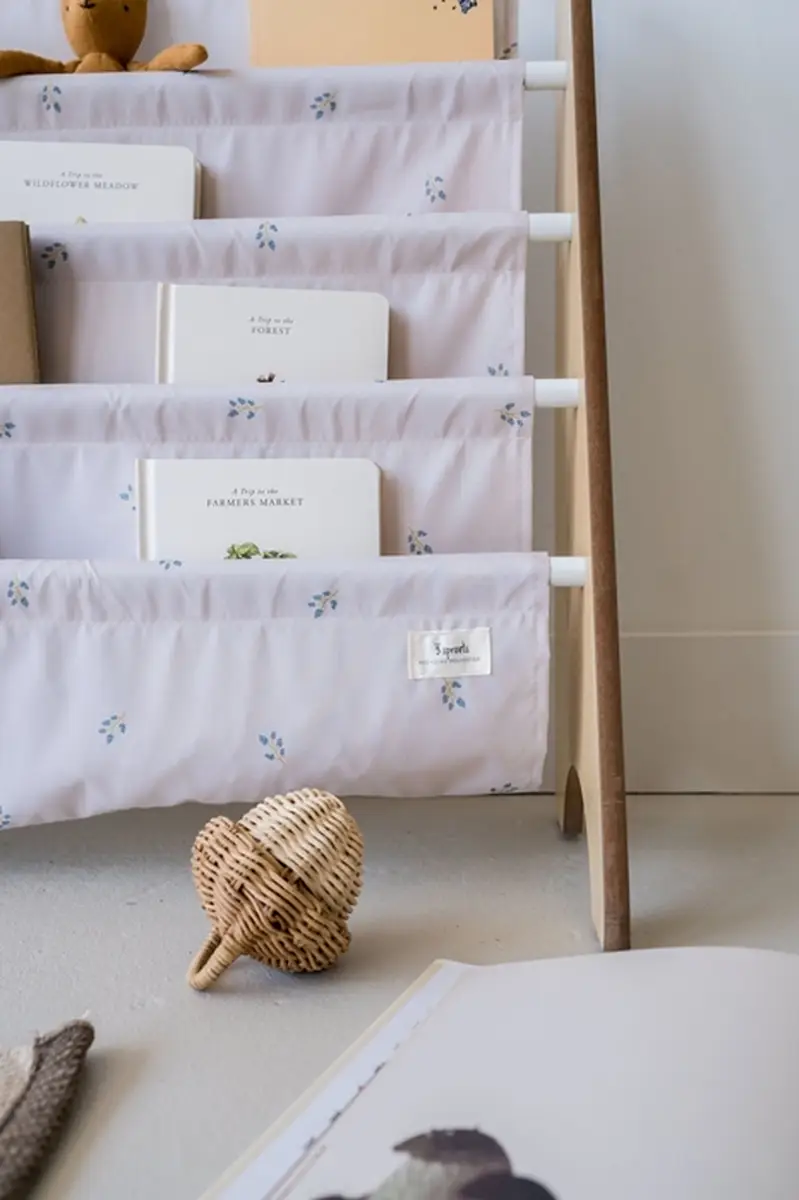 Stojak na książki z materiałowymi kieszeniami w jasnym kolorze z drobnym wzorem dla dzieci. 3 Sprouts Stojak na Książki Recycled Blueberry Taupe