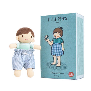 Miękka laleczka chłopiec ubrany w niebieskie spodnie w kratę i zieloną koszulkę dla dziecka z pudełkiem z ilustracją chłopca. ThreadBear Design Laleczka w pudełku chłopiec Jack