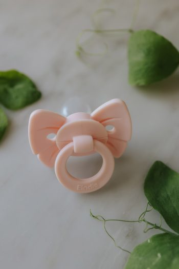 Smoczek silikonowy dla niemowlaka w kolorze jasnoróżowym z ozdobą w kształcie kokardki. Elodie Details smoczek silikonowy Binky Bow 0-6 m misty pink