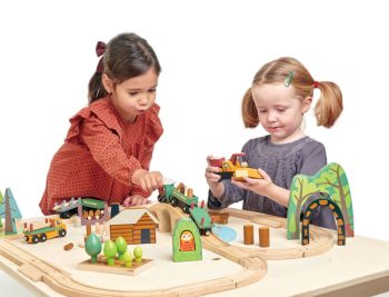 Dwie dziewczynki bawiące się drewnianą kolejką z torami i elementami lasu dla dzieci. Tender Leaf Toys Drewniana kolejka Podróż po lesie