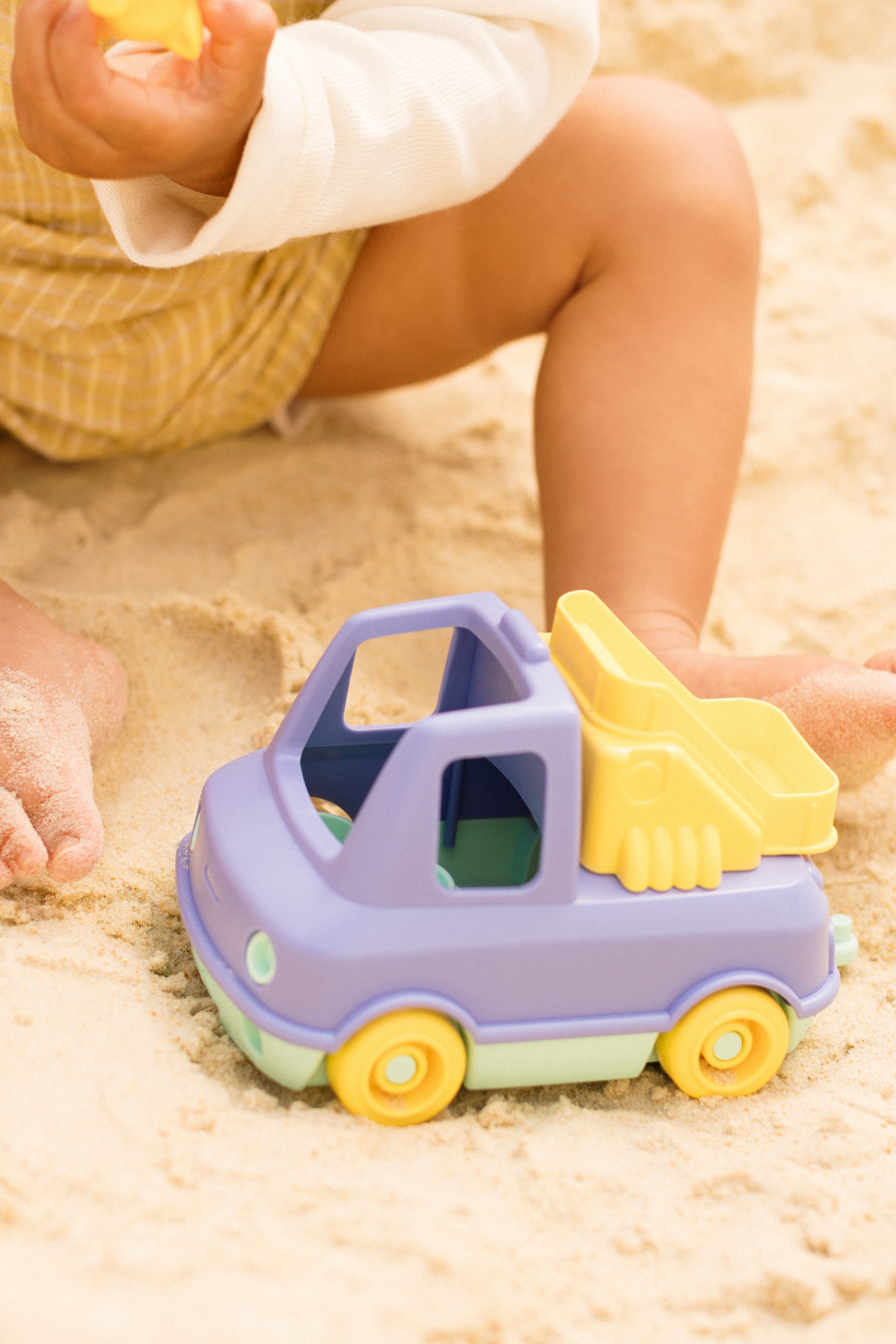Fioletowo-żółty plastikowy wóz strażacki zabawka dla dziecka na piasku. Le Jouet Simple Pierwszy wóz strażacki pomarańczowy auto