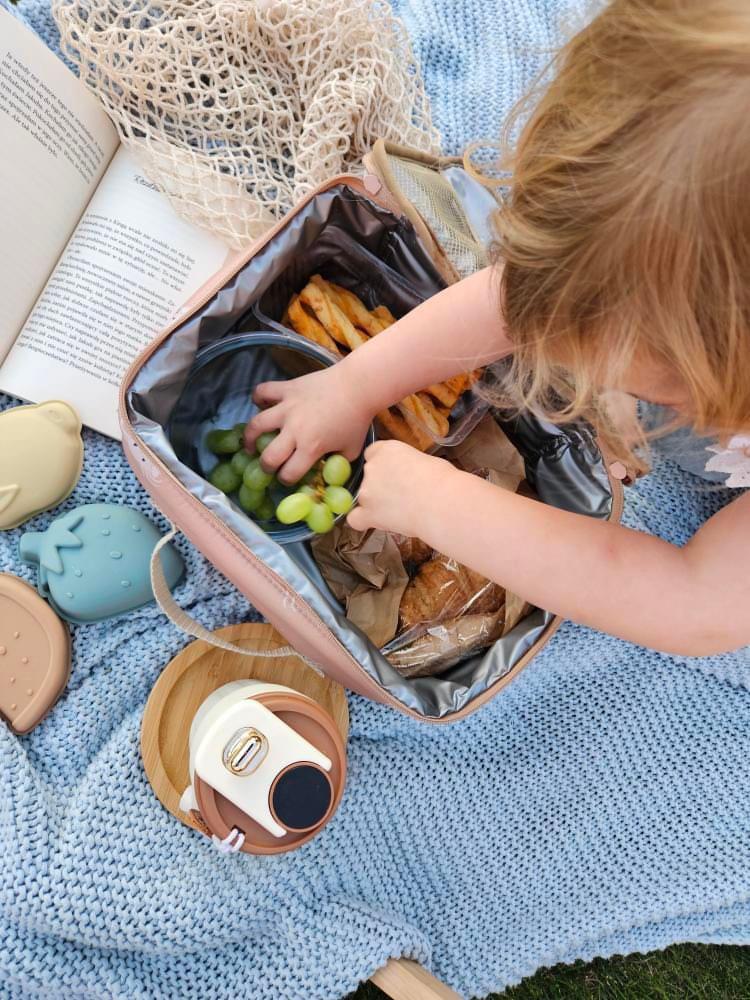 Torba termiczna na lunch w kolorze dębowym z jedzeniem dla dziecka na niebieskim kocu. Vanilla Copenhagen Torba termiczna Cooler Bag NEO LILY Oak