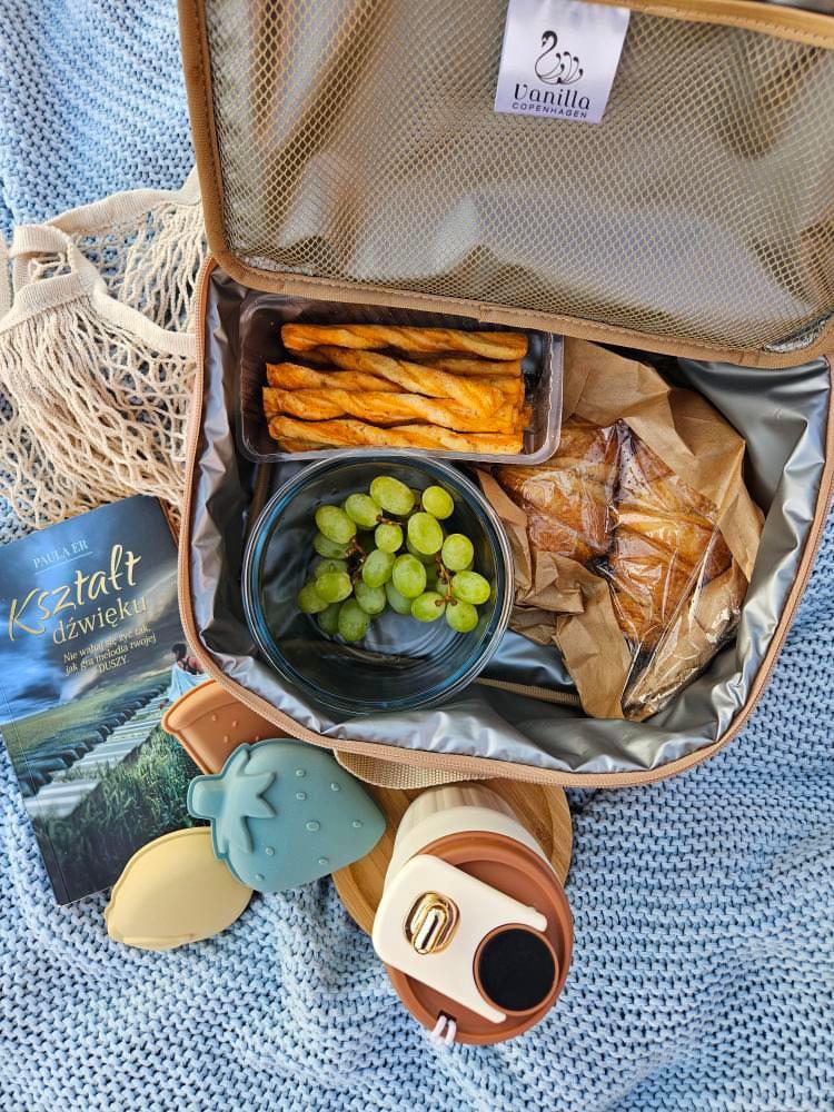 Torba termiczna na lunch beżowa z jedzeniem i akcesoriami dla dziecka na kocu. Vanilla Copenhagen Torba termiczna Cooler Bag NEO LILY Oak