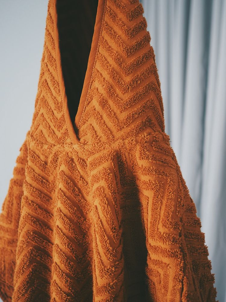 Pomarańczowe ponczo kąpielowe dla dziecka z wzorem zygzak z miękkiego materiału. Filibabba Poncho Zigzag Rust
