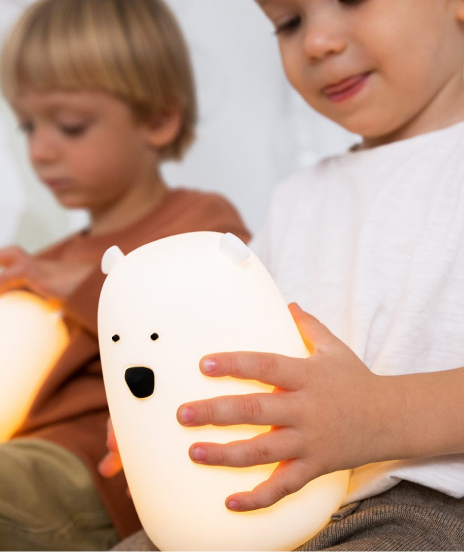 Biała silikonowa lampka nocna w kształcie misia trzymana przez dziecko. Rabbit&Friends Miś Duży Lampka Silikonowa Biała