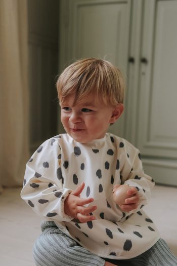 Śliniak z długim rękawem w czarne plamy dla dziecka na jasnym tle. Elodie Details Śliniak z długim rękawem dalmatian dots grande