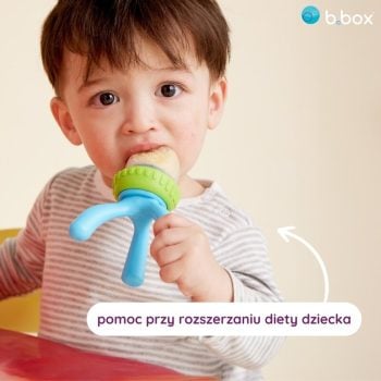 Dziecko trzyma i gryzie silikonowy gryzak do podawania pokarmu w kolorze niebiesko-zielonym dla niemowląt. b.box Gryzak silikonowy do podawania pokarmu Ocean Breeze