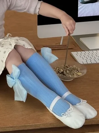 Niebieskie podkolanówki z tiulową kokardą dla dziecka na tle biurka i komputera. Fig&Pear Podkolanówki z tiulową niebieską kokardą