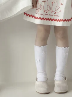 Białe prążkowane podkolanówki z kokardkami dla dziecka. Fig&Pear Białe skarpetki prążkowane z kokardkami
