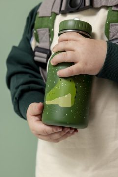 Zielony bidon 350 ml z motywem aligatora dla dziecka trzymany w dłoniach dziecka. Trixie Butelka bidon 350ml Aligator Baby