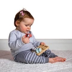 Niemowlę bawiące się bambusowym sorterem z silikonowymi elementami siedząc na dywanie. Mary Meyer Bambusowy Sorter z Silikonowymi Elementami