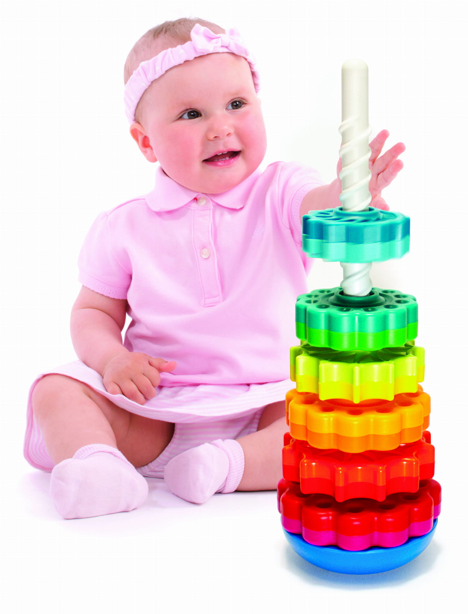 Niemowlę w różowej sukience bawiące się kolorową zakręconą wieżą SpinAgain z klocków 3D. Fat Brain Toy Co. Zakręcona Wieża SpinAgain