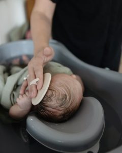 Delikatna szczotka do ciemieniuchy dla niemowląt w kolorze blush używana do pielęgnacji główki dziecka. Mushie Szczotka na Ciemieniuchę dla Niemowląt Blush / Shifting Sa
