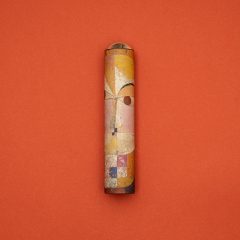 Kalejdoskop z motywem obrazu Senecio Paula Klee na tle pomarańczowym. Londji Kalejdoskop Paul Klee Senecio