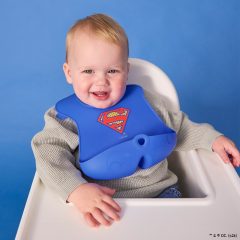 Niebieski silikonowy śliniak dla dziecka z motywem supermana z otwartą kieszonką. b.box Superman by Śliniak z otwartą kieszonką
