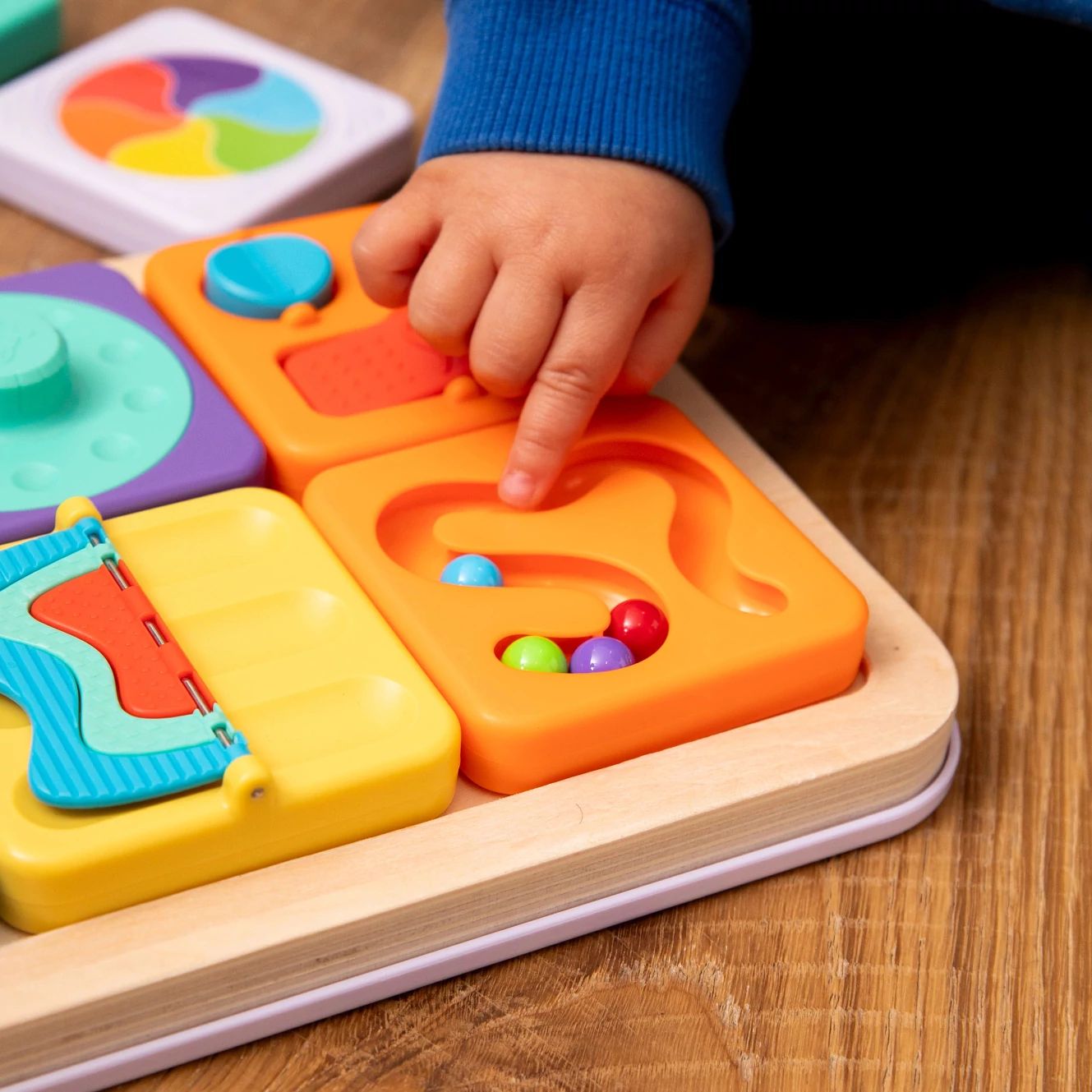 Drewniana sensoryczna zabawka zręcznościowa z kolorowymi kwadratami i kuleczkami dla dziecka. Fat Brain Toy Co. PlayTab Sensoryczne Kwadraty Zestaw 3 ze Zgarniaczem Kuleczek
