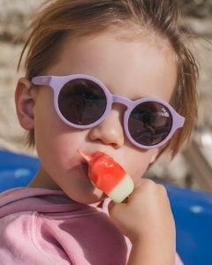 Fioletowe okulary przeciwsłoneczne dla dziecka w wieku 1 5-3 lat dziecko jedzące loda. OKKY Okulary przeciwsłoneczne lilac 1.5-3 lat