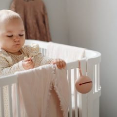 Okrągłe silikonowe etui na smoczek w kolorze pudrowego różu z uchwytem do zawieszenia. Mushie Etui na smoczek Blush