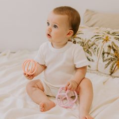 Dwie sensoryczne piłki dla niemowlaka w kolorze różowym i jasnoróżowym z ażurowym wzorem. Jellystone Sensoryczne piłki 2w1 Bubblegum & Peach