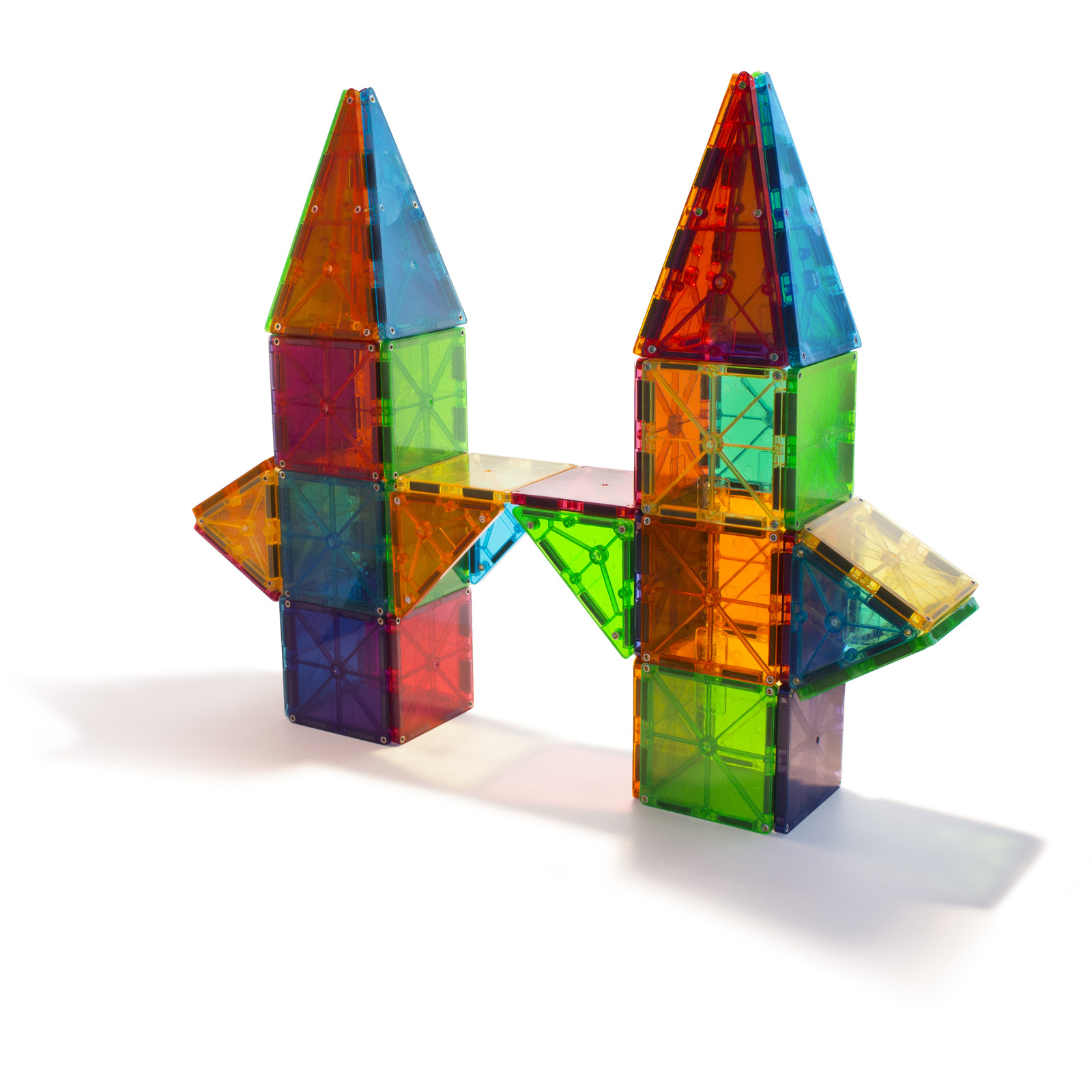 Kolorowe magnetyczne klocki konstrukcyjne z przezroczystego plastiku ułożone w wieże i mostek. Magna-Tiles Klocki Magnetyczne Classic 100el