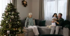 Rodzina siedząca na kanapie przy choince podczas świątecznego spotkania